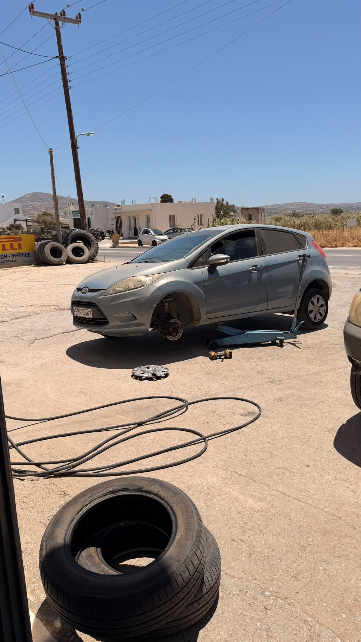 The Fiesta on a jack at a tyre shop with a wheel removed