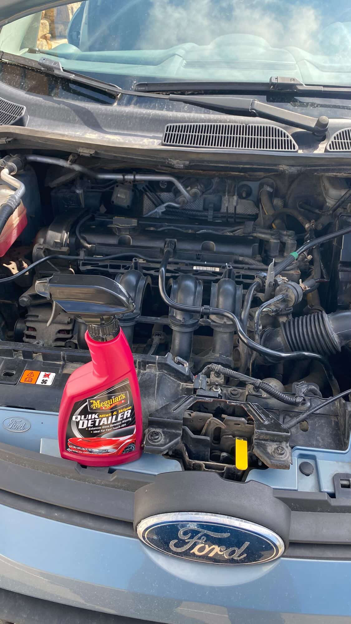 Engine bay of the Fiesta with a bottle of Quik Detailer